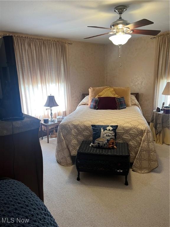 bedroom with carpet floors, multiple windows, and a ceiling fan