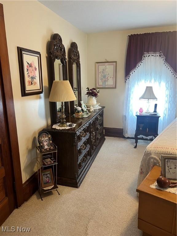 bedroom with baseboards and light carpet