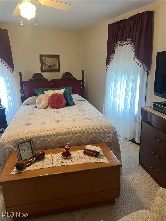 bedroom featuring ceiling fan and light carpet
