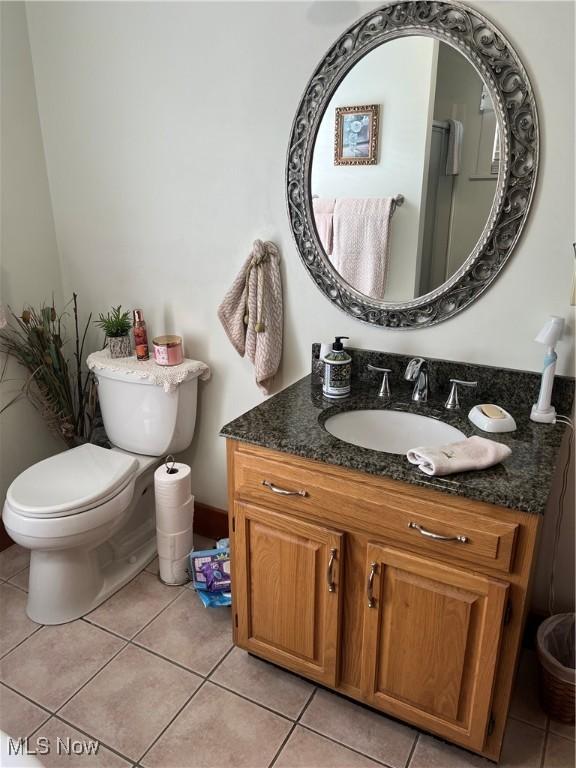 bathroom with vanity, tile patterned flooring, and toilet