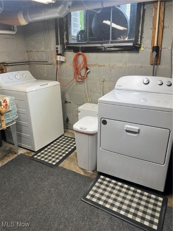 laundry room featuring laundry area, concrete block wall, and washing machine and clothes dryer