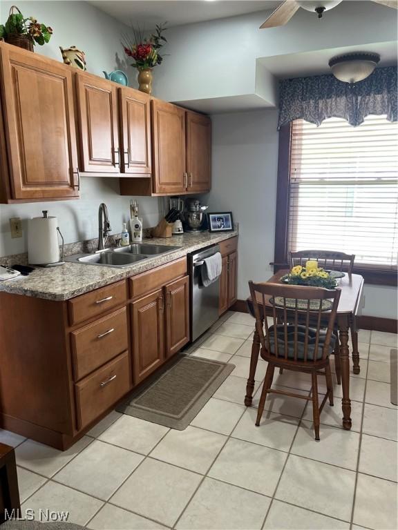 kitchen featuring ceiling fan, light countertops, brown cabinets, a sink, and dishwasher