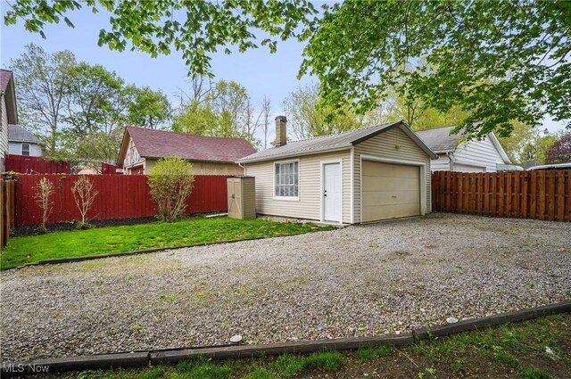 288 College St, Wadsworth, OH 44281 - view of front of house featuring a fenced backyard, an outdoor structure, metal roof, and a garage