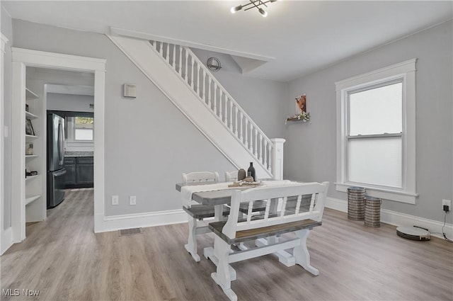 288 College St, Wadsworth, OH 44281 - dining space with light wood-type flooring, stairs, baseboards, and visible vents