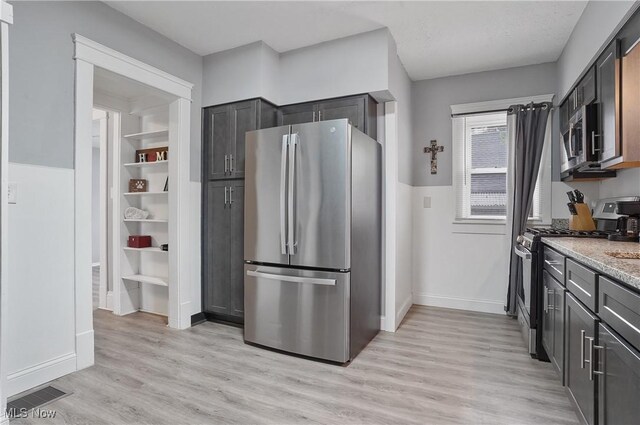 288 College St, Wadsworth, OH 44281 - kitchen featuring light stone counters, light wood finished floors, stainless steel appliances, baseboards, and visible vents