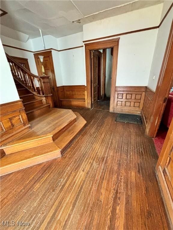 interior space featuring stairs, wainscoting, and hardwood / wood-style flooring