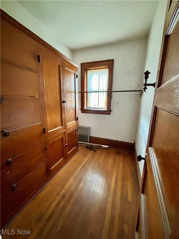 interior space featuring baseboards and wood finished floors