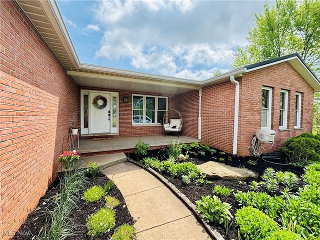 entrance to property with brick siding and covered porch