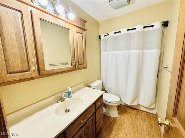 full bathroom featuring toilet, shower / bathtub combination with curtain, wood finished floors, and vanity