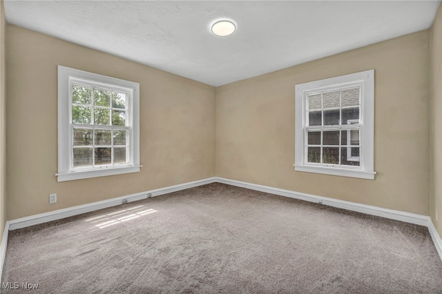 empty room featuring carpet floors and baseboards