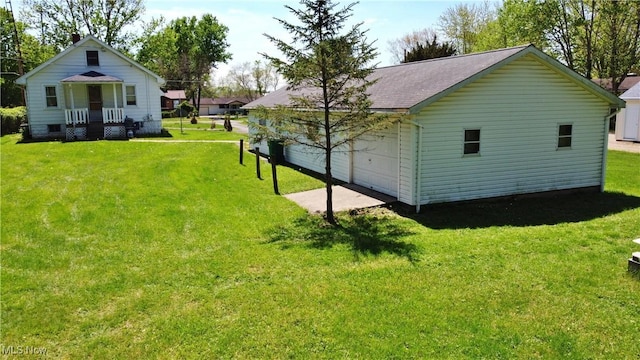 view of property exterior featuring a yard and a detached garage
