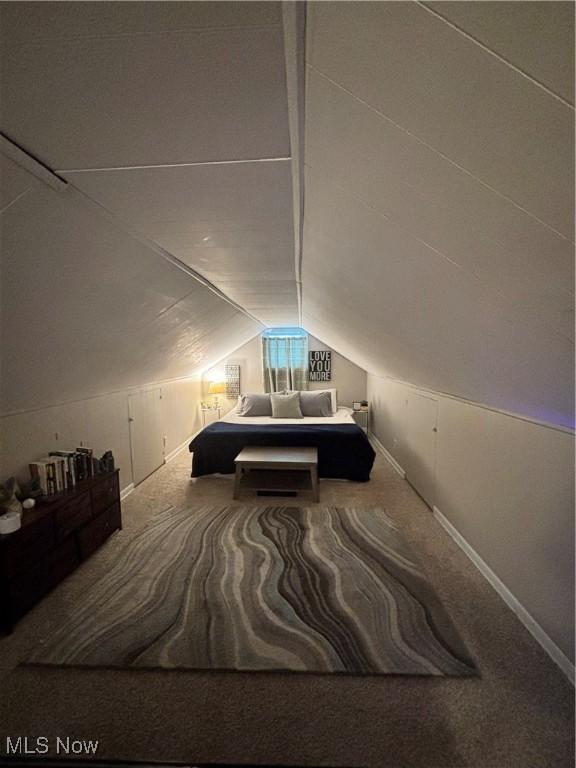 bedroom featuring carpet floors, baseboards, and lofted ceiling