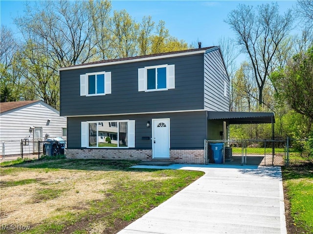 view of front of house featuring fence, brick siding, a gate, concrete driveway, and a carport