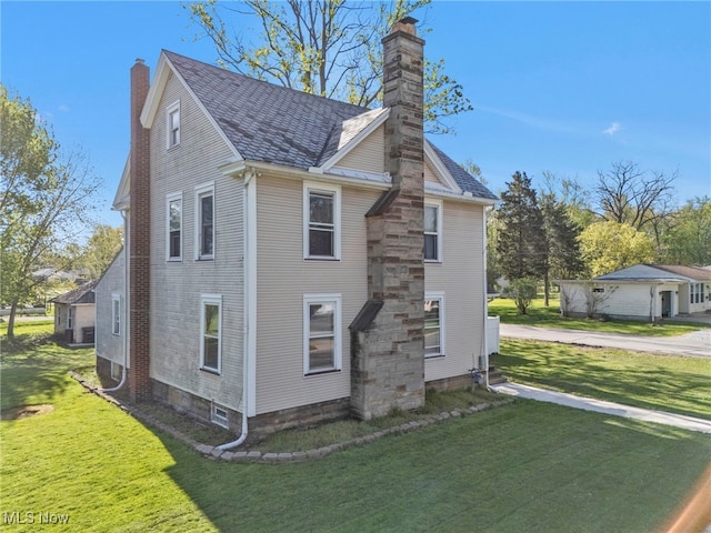 483 N Main St, Amherst, OH 44001 - view of property exterior featuring a chimney and a lawn