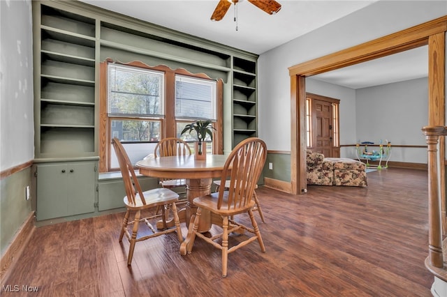 dining area featuring baseboards, a ceiling fan, and dark wood finished floors