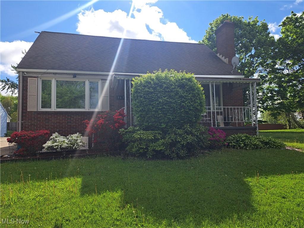 367 6th St, Campbell, OH 44405 - view of front of house featuring a chimney, a front yard, brick siding, and covered porch