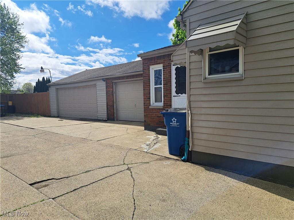367 6th St, Campbell, OH 44405 - garage with driveway and fence