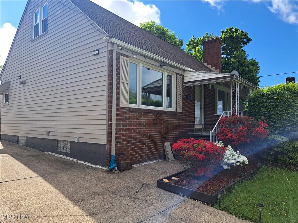 367 6th St, Campbell, OH 44405 - view of property exterior featuring brick siding, a shingled roof, and a chimney