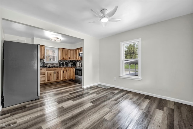 838 N Lincoln Ave, Alliance, OH 44601 - kitchen featuring brown cabinetry, dark wood-style flooring, appliances with stainless steel finishes, and a wealth of natural light