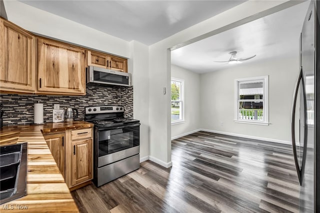 838 N Lincoln Ave, Alliance, OH 44601 - kitchen with decorative backsplash, wooden counters, dark wood-style floors, a ceiling fan, and appliances with stainless steel finishes