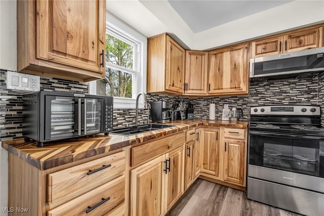 838 N Lincoln Ave, Alliance, OH 44601 - kitchen featuring butcher block counters, dark wood-style floors, tasteful backsplash, a sink, and stainless steel appliances