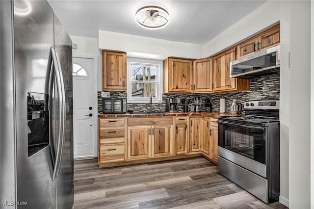 838 N Lincoln Ave, Alliance, OH 44601 - kitchen featuring dark countertops, appliances with stainless steel finishes, decorative backsplash, and a sink