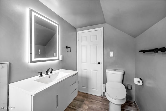 838 N Lincoln Ave, Alliance, OH 44601 - bathroom with wood finished floors, vanity, baseboards, toilet, and lofted ceiling
