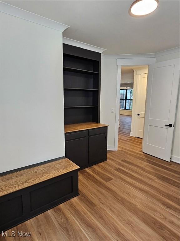 mudroom with crown molding, baseboards, and light wood finished floors