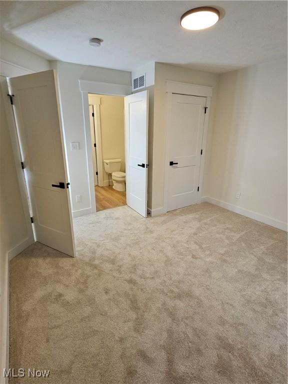 unfurnished room featuring carpet floors, baseboards, and visible vents