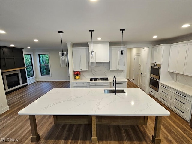 kitchen featuring recessed lighting, dark wood-type flooring, a sink, appliances with stainless steel finishes, and backsplash