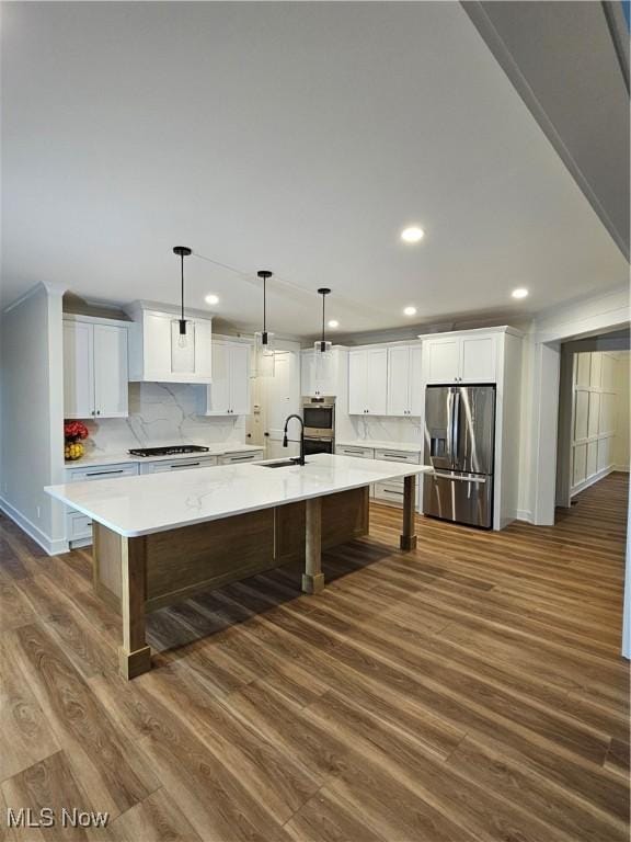 kitchen with a spacious island, recessed lighting, light countertops, dark wood finished floors, and stainless steel appliances