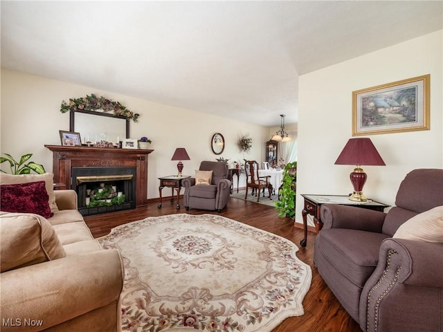 living room featuring baseboards, wood finished floors, and a fireplace