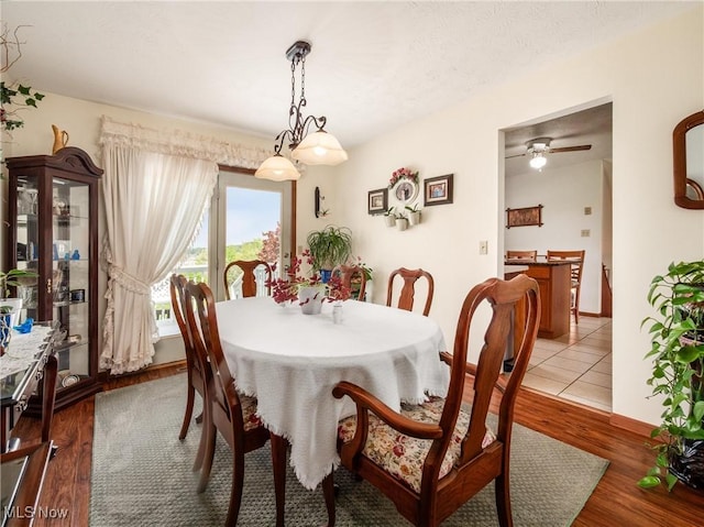 dining area featuring baseboards, ceiling fan, and wood finished floors