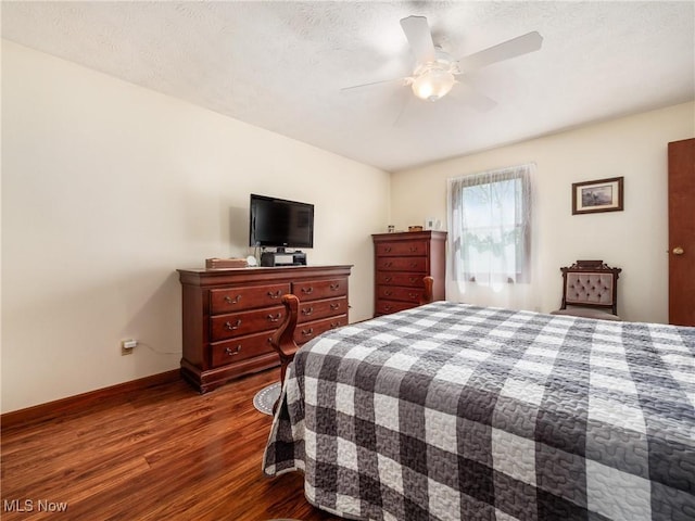 bedroom with baseboards, ceiling fan, dark wood-style floors, and a textured ceiling