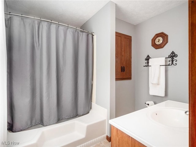 full bath with a textured ceiling, a shower with shower curtain, and vanity