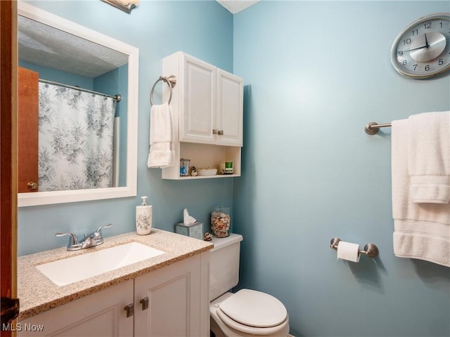 bathroom with vanity, toilet, and a shower with curtain