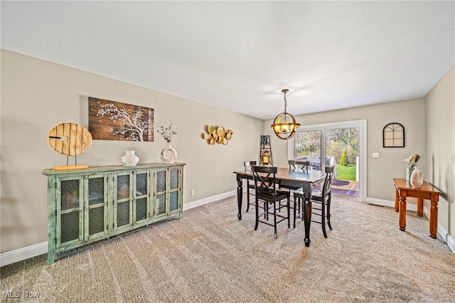 carpeted dining area with baseboards and a notable chandelier