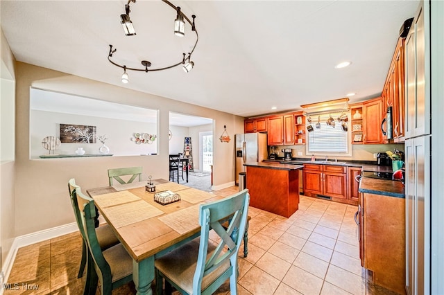 dining space with a healthy amount of sunlight, baseboards, and light tile patterned flooring