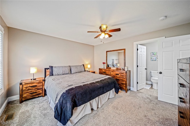 bedroom with light colored carpet, baseboards, ensuite bathroom, and ceiling fan
