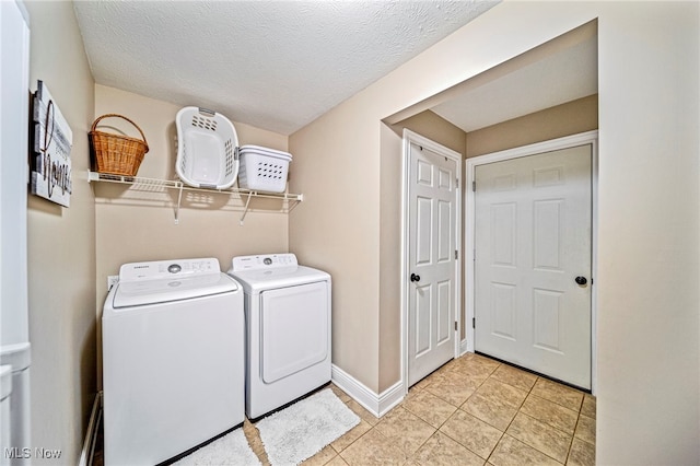 clothes washing area with baseboards, laundry area, light tile patterned flooring, and independent washer and dryer