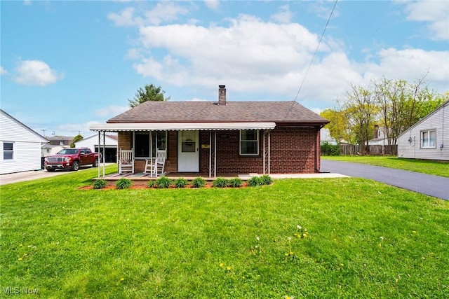 7377 Sierra Madre Trl, Boardman, OH 44512 - view of front of home with a front yard, roof with shingles, a chimney, brick siding, and a porch
