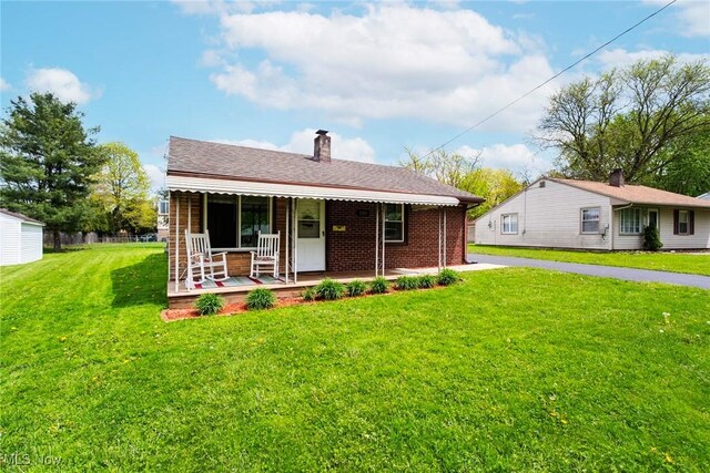 7377 Sierra Madre Trl, Boardman, OH 44512 - rear view of house with covered porch, a lawn, a chimney, and brick siding