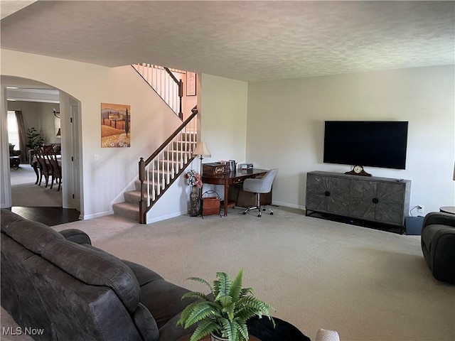 840 Sunrise Cir, Aurora, OH 44202 - living room with a textured ceiling, arched walkways, carpet floors, baseboards, and stairs