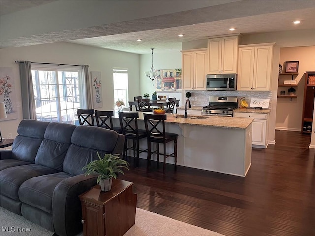 840 Sunrise Cir, Aurora, OH 44202 - living room with recessed lighting, baseboards, dark wood-style floors, and an inviting chandelier