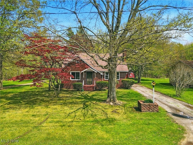 view of front facade featuring brick siding, a front lawn, and driveway