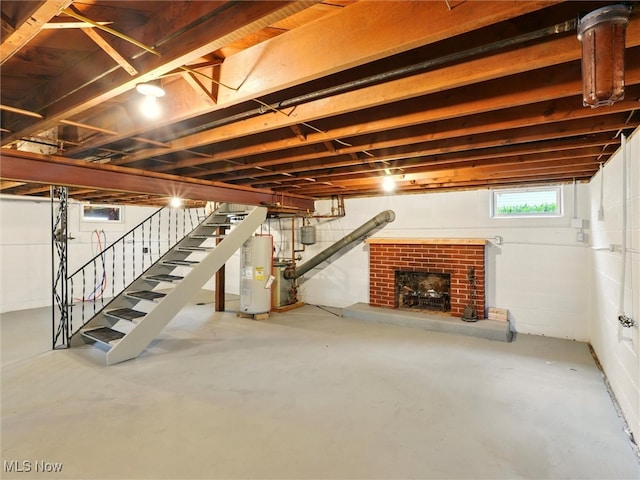 below grade area featuring a brick fireplace, water heater, and stairway