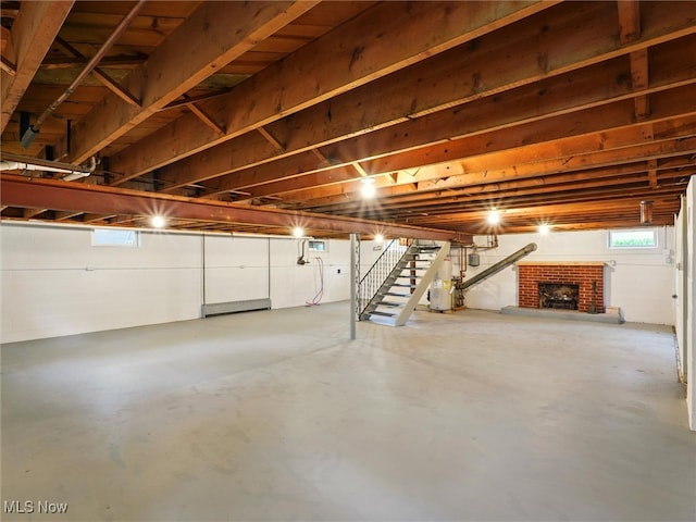 below grade area with stairway, water heater, and a brick fireplace