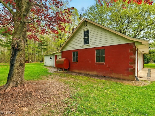 view of side of home featuring a lawn and heating fuel