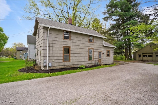460 Carthage Ave, Kent, OH 44240 - exterior space featuring a detached garage, a chimney, a shingled roof, and a front yard
