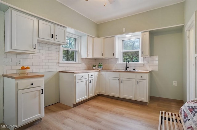 460 Carthage Ave, Kent, OH 44240 - kitchen featuring tasteful backsplash, light wood-type flooring, a sink, light countertops, and white cabinetry